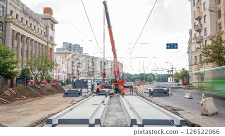 Installing concrete plates by crane at road construction site timelapse. Installing concrete plates by crane at road construction site timelapse. 126522066