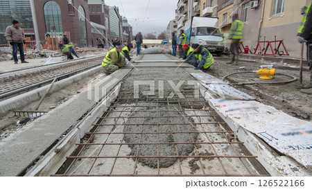 Pouring ready-mixed concrete after placing steel reinforcement to make the road by concrete mixer timelapse hyperlapse. 126522166