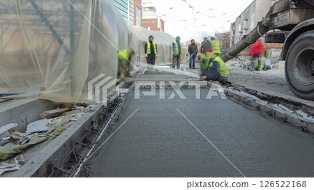 Pouring ready-mixed concrete after placing steel reinforcement to make the road by concrete mixer timelapse hyperlapse. 126522168