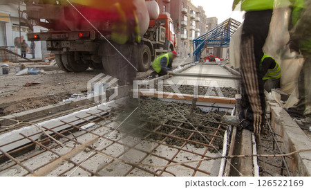 Pouring ready-mixed concrete after placing steel reinforcement to make the road by concrete mixer timelapse hyperlapse. Pouring ready-mixed concrete after placing steel reinforcement to make the road by concrete mixer timelapse hyperlapse. 126522169