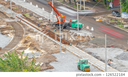 Orange construction telescopic mobile crane unloading tram rails aerial timelapse. Orange construction telescopic mobile crane unloading tram rails aerial timelapse. 126522184