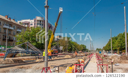 Yellow construction telescopic mobile crane moving tram rails timelapse. 126522190