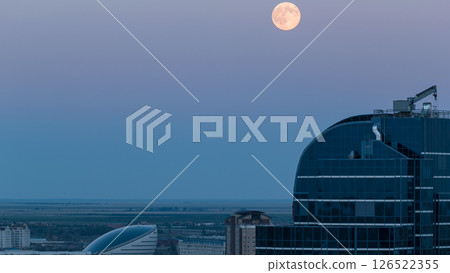 Nazarbayev Center and blue tower, after Sunset with full moon rising. Astana, Kazakhstan Nazarbayev Center and blue tower, after Sunset with full moon rising. Astana, Kazakhstan 126522355