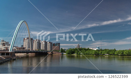 Bridge over Ishim with park timelapse with the transport and clouds on the background. Central Asia, Kazakhstan, Astana Bridge over Ishim with park timelapse with the transport and clouds on the background. Central Asia, Kazakhstan, Astana 126522399