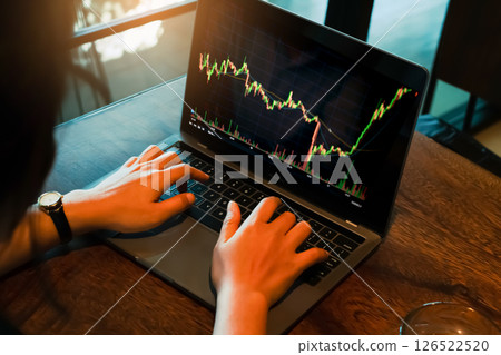 Asian young woman 30s looking stock tickers or graphs cryptocurrency trading platforms on laptop with a cup of coffee on the table at home office in the morning. Selective focus Asian young woman 30s looking stock tickers or graphs cryptocurrency trading platforms on laptop with a cup of coffee on the table at home office in the morning. Selective focus 126522520