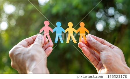 Hands holding colorful paper people chain, representing diversity and inclusion Hands holding colorful paper people chain, representing diversity and inclusion 126523178