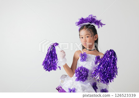 Smiling cheerleader girl wearing purple and white outfit with pom-poms. Studio portrait exuding energy and joy against a white background. cheerleader kid Smiling cheerleader girl wearing purple and white outfit with pom-poms. Studio portrait exuding energy and joy against a white background. cheerleader kid 126523339