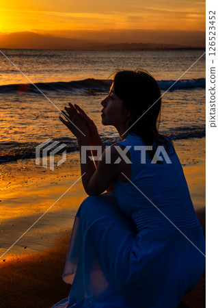 A woman looking at the sea at sunset 126523452