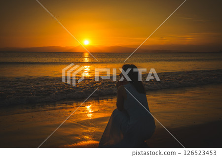 A woman looking at the sea at sunset 126523453