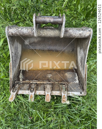 Rusty metal bucket is sitting on the grass Rusty metal bucket is sitting on the grass 126524011