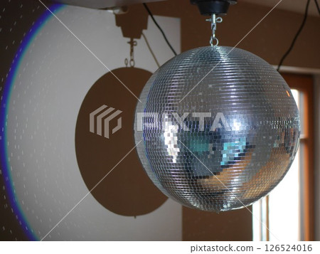 Silver disco ball is hanging from the ceiling Silver disco ball is hanging from the ceiling 126524016