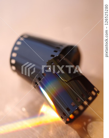 Roll of film is shown with a rainbow in the background Roll of film is shown with a rainbow in the background 126525280