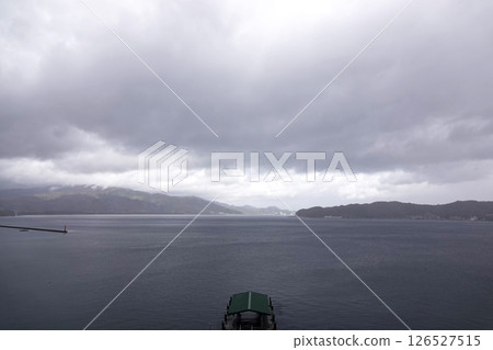 天氣多雲。宮津灣雲層濃厚。碼頭尖端和防波堤燈塔。 126527515