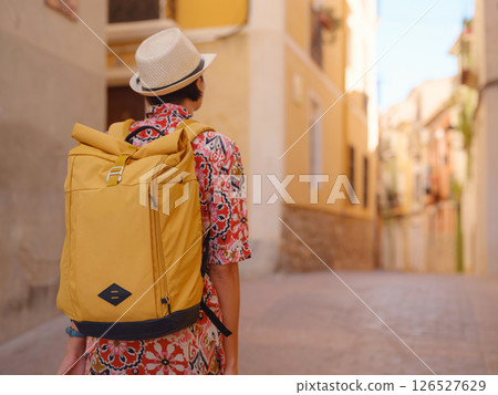 Woman strolls through colorful streets of Spanish coastal town 126527629
