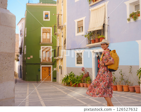 Woman strolls through colorful streets of Spanish coastal town 126527632