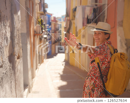 Woman strolls through colorful streets of Spanish coastal town 126527634