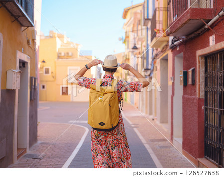 Woman strolls through colorful streets of Spanish coastal town 126527638