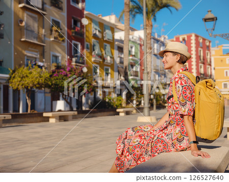 Woman strolls through colorful streets of Spanish coastal town 126527640