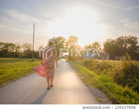 boho chic woman in a floral dress in European countryside 126527698