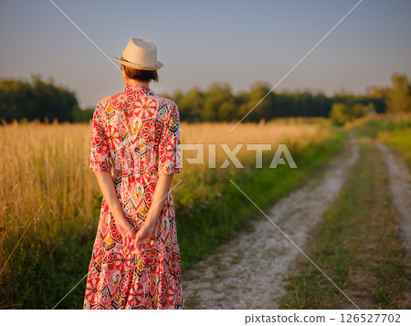 boho chic woman in a floral dress in European countryside boho chic woman in a floral dress in European countryside 126527702