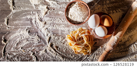 Portion of homemade noodles on floured kitchen table flat lay cooking background with copy-space 126528119