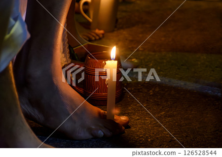 Bare feet holding a candle 126528544