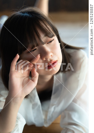 Young woman lying on flooring 126528887