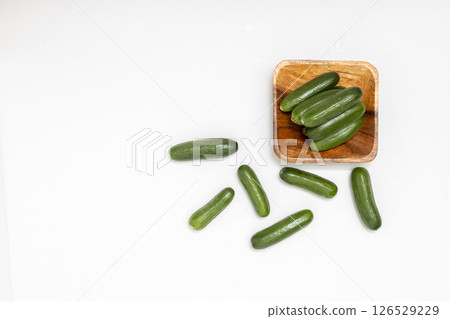 小木盤上的迷你黃瓜。白色背景上小黃瓜的庫存照片 126529229