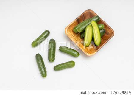 小木盤上的迷你黃瓜。白色背景上小黃瓜的庫存照片 126529239