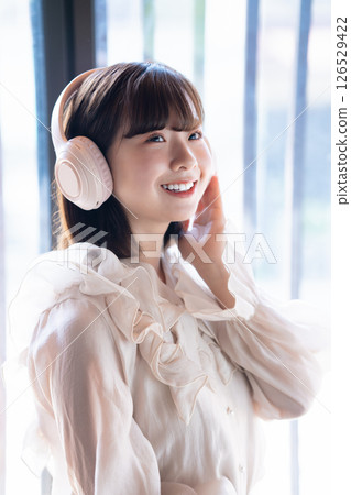 Close-up of a young woman listening to music through headphones 126529422