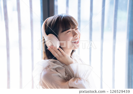 A young woman listening to music with headphones 126529439