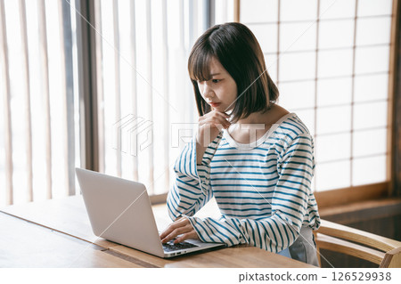 一位年輕女子在日式房間使用筆記型電腦 126529938