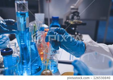 Scientist pipetting medical samples into microplate in laboratory Scientist pipetting medical samples into microplate in laboratory 126530840