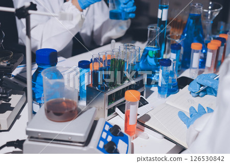 Scientist pipetting medical samples into microplate in laboratory 126530842
