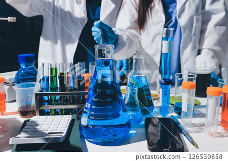 Scientist pipetting medical samples into microplate in laboratory 126530858