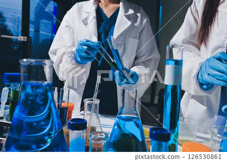 Scientist pipetting medical samples into microplate in laboratory Scientist pipetting medical samples into microplate in laboratory 126530861