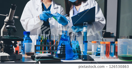 Scientist pipetting medical samples into microplate in laboratory 126530863