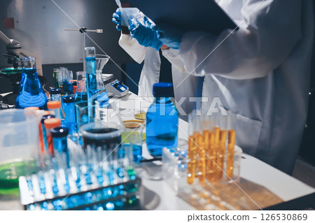 Scientist pipetting medical samples into microplate in laboratory 126530869
