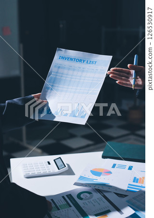 Group of business women working on a financial data expenses document. Group of business women working on a financial data expenses document. 126530917