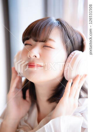 A young woman listening to music with headphones 126531508