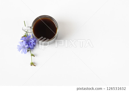 Glass cup with chicory drink and blue chicory flowers on gray background. Healthy eating Glass cup with chicory drink and blue chicory flowers on gray background. Healthy eating 126531632