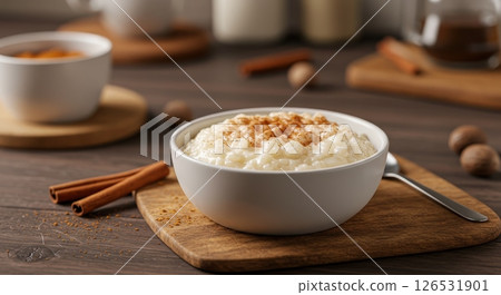 Creamy rice pudding in a white bowl, topped with cinnamon on a wooden board 126531901