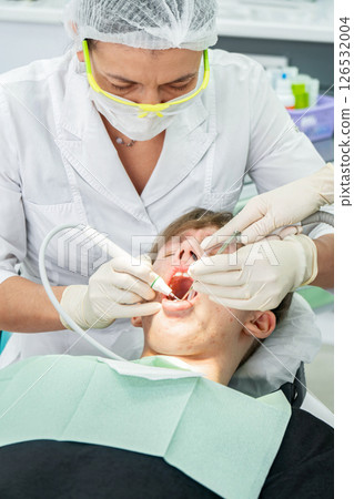 Dental procedure during an examination with a young patient in a modern clinic setting 126532004