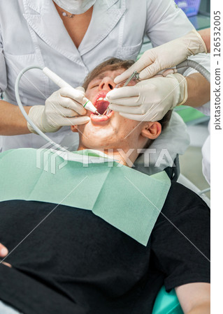 Teenager receiving dental treatment in modern clinic during daytime 126532005