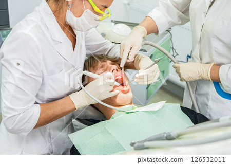 Teenager receiving dental treatment in modern clinic during daytime 126532011