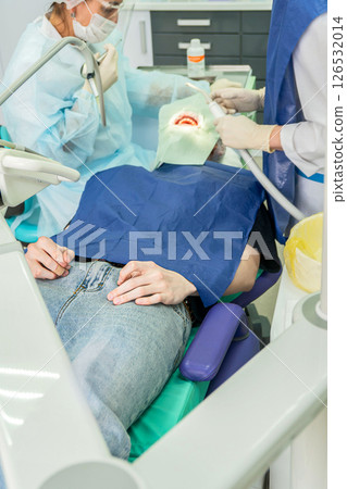 Dental procedure with medical professionals using tools in modern clinic setting Dental procedure with medical professionals using tools in modern clinic setting 126532014