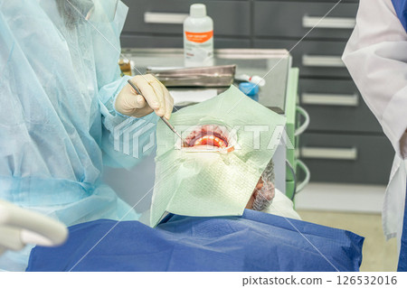 Dental procedure with medical professionals using tools in modern clinic setting 126532016