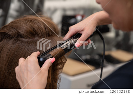 The Art of Styling Hair with a Flat Iron in a Professional Salon Setting for Clients The Art of Styling Hair with a Flat Iron in a Professional Salon Setting for Clients 126532188