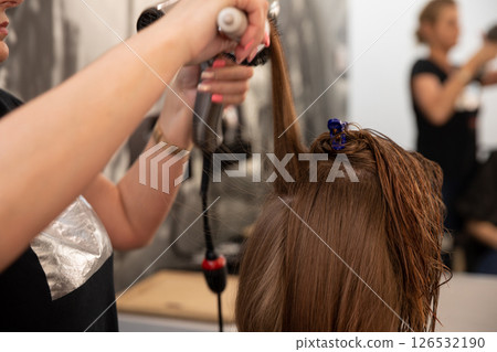 Styling Hair with Professional Tools at a Salon for Stunning Looks and Beautiful Transformations 126532190