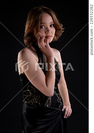 An Elegant Young Woman Dressed in a Stunning Black Dress Posing Gracefully with Charm An Elegant Young Woman Dressed in a Stunning Black Dress Posing Gracefully with Charm 126532262